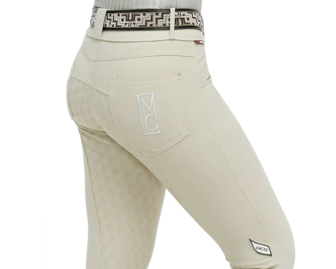 Beige equestrian pants with a patterned belt on a white background