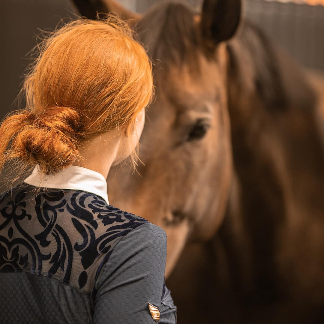 Equestrian Model patting a horse wearing Emcee Apparel's Ravello competition shirt