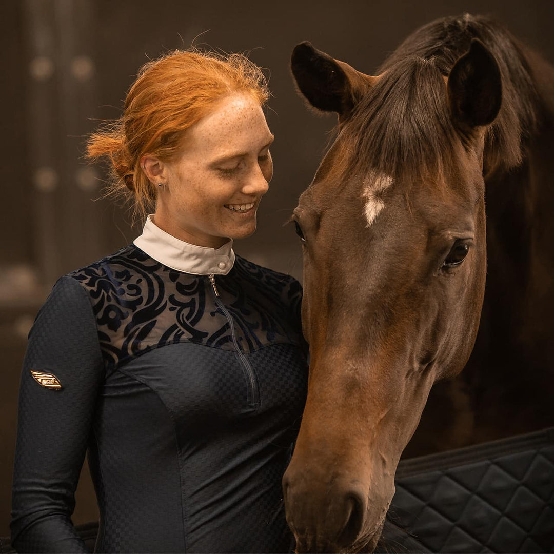 Equestrian Model patting a horse wearing Emcee Apparel's Ravello competition shirt
