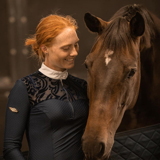 Equestrian Model patting a horse wearing Emcee Apparel's Ravello competition shirt