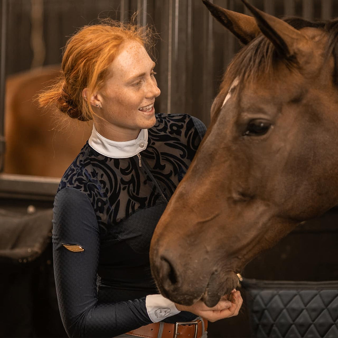 Equestrian Model patting a horse wearing Emcee Apparel's Ravello competition shirt
