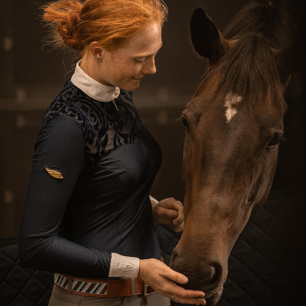 Equestrian Model patting a horse wearing Emcee Apparel's Ravello competition shirt